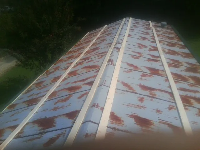 Rusted metal roof panels with new wood purlins before replacement — Storm Damage Roof Repair in New Waterford by Roofing Brothers