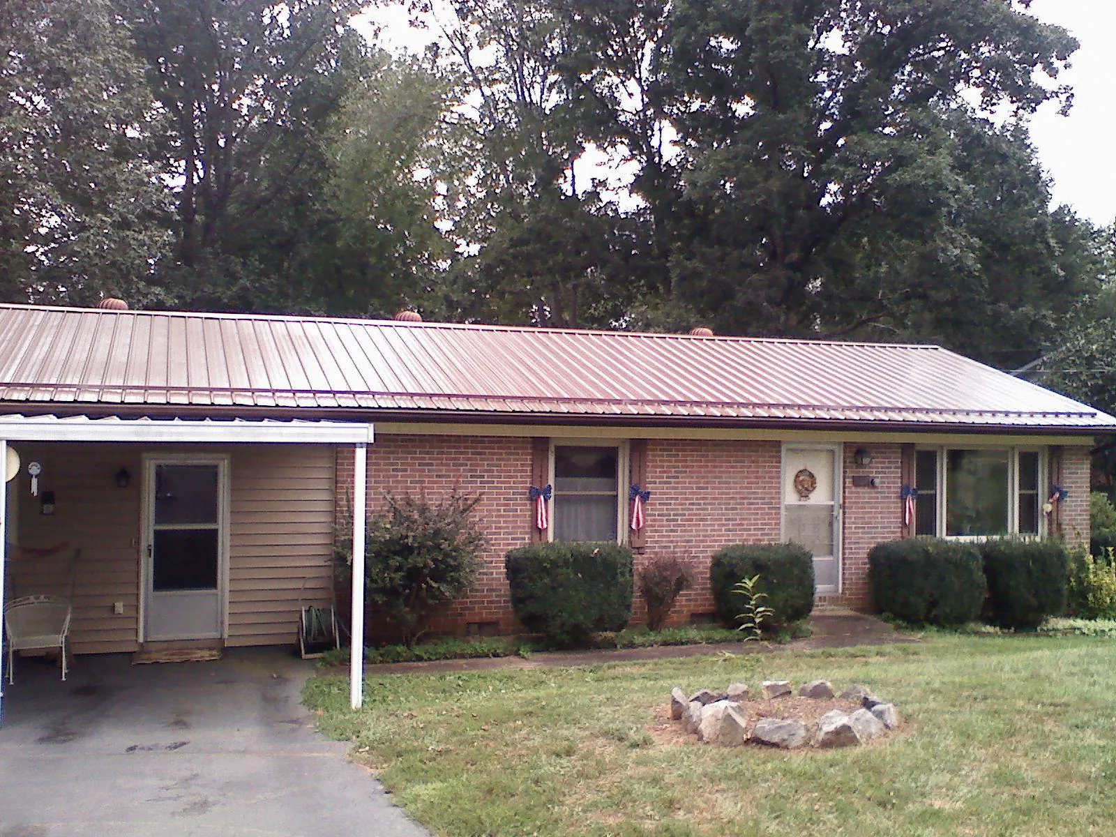 Bronze metal roof and carport on a brick ranch home — Roof Repair work by our crew in New Waterford