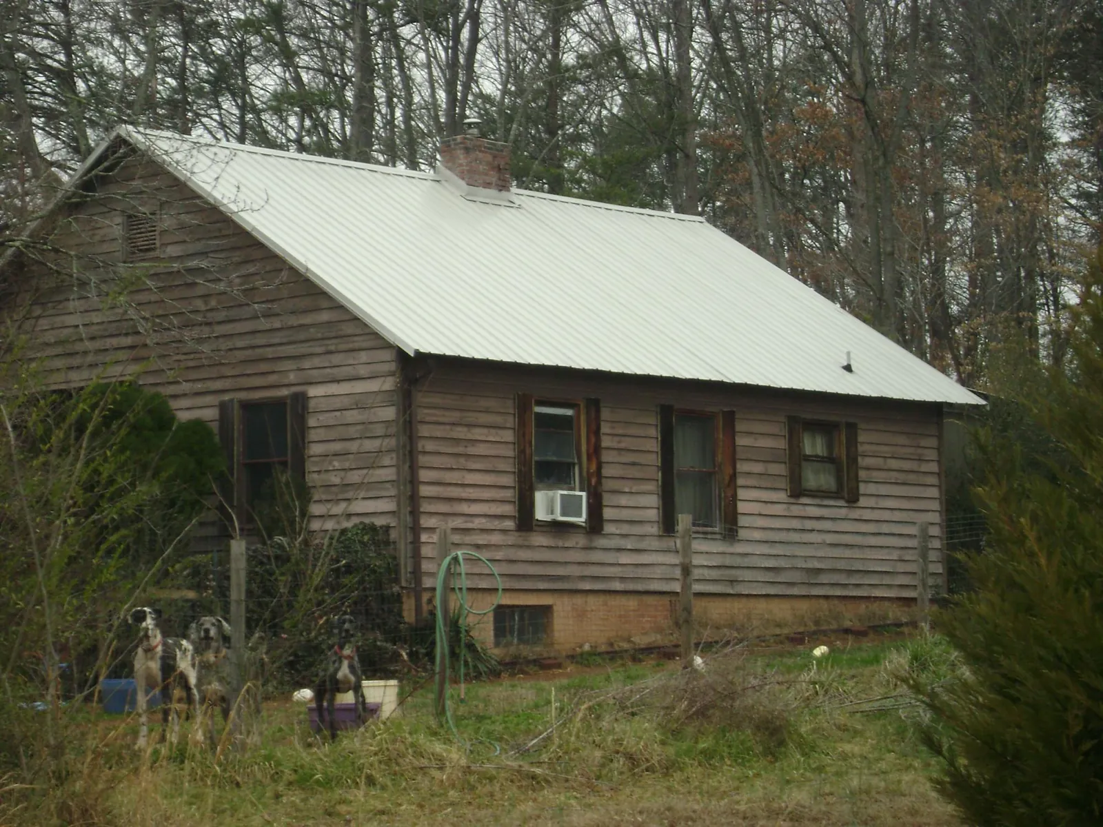 White metal roof on an old wood sided farmhouse, from a Metal Roof Installation job in New Waterford